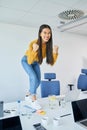 Young Asian woman clenching her fists in joy at office