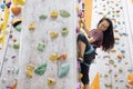 A young Asian woman on a climbing wall. A Korean girl climbs a bouldering wall Royalty Free Stock Photo