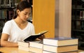 Young Asian woman college students research and learn from textbooks in the university library