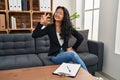 Young asian woman at consultation office smiling looking to the camera showing fingers doing victory sign Royalty Free Stock Photo