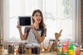 Young Asian woman cooking in the kitchen and holding digital tablet Royalty Free Stock Photo