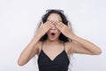 A young asian woman covers her eyes with her hands. Anticipating a surprise gift or hide and seek. on a white background