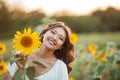 Young Asian woman with curly hair in a field of sunflowers at sunset. Portrait of a young beautiful asian woman in the sun Royalty Free Stock Photo