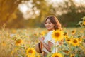 Young Asian woman with curly hair in a field of sunflowers at sunset. Portrait of a young beautiful asian woman in the sun Royalty Free Stock Photo