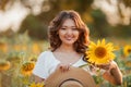 Young Asian woman with curly hair in a field of sunflowers at sunset. Portrait of a young beautiful asian woman in the sun Royalty Free Stock Photo