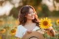 Young Asian woman with curly hair in a field of sunflowers at sunset. Portrait of a young beautiful asian woman in the sun Royalty Free Stock Photo