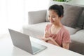 Young Asian woman deaf disabled using laptop computer for online video conference call learning and communicating in sign language Royalty Free Stock Photo