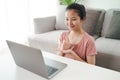 Young Asian woman deaf disabled using laptop computer for online video conference call learning and communicating in sign language Royalty Free Stock Photo