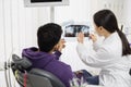 Young asian woman dentist holding x ray image. Royalty Free Stock Photo