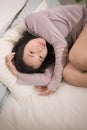 Young Asian woman depressed - young beautiful and sad Korean girl on bed with pillow feeling unhappy and broken heart suffering