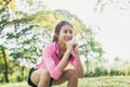 Young asian woman do squats for exercise to build up her beauty body in park environ with green trees.