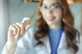 Young asian woman doctor looking at camera.Smiling female pharmacist holding a pill, health care and prevention concept, hand Royalty Free Stock Photo