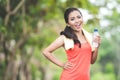 Young asian woman after doing excercise outdoor in a park, holding a bottle of water Royalty Free Stock Photo