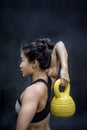 Young Asian woman doing exercise with kettle bell