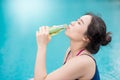 Young Asian woman drinking sport drink at swimming pool Royalty Free Stock Photo