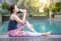 Young Asian woman drinking water at swimming pool Royalty Free Stock Photo