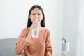 Young Asian woman drinks water from a bottle at home. Royalty Free Stock Photo