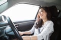 Young Asian woman driving a car and smile happily with glad positive expression during the drive to travel journey. Royalty Free Stock Photo