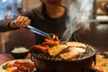 Young Asian woman eating BBQ in restaurant. Korean barbecue or Yakiniku in Japanese style. Closeup Royalty Free Stock Photo