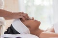 Young asian woman enjoying face massage in luxurious beauty salon