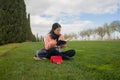 Young Asian woman enjoying novel on grass - lifestyle portrait of young happy and pretty Chinese girl reading a book at beautiful Royalty Free Stock Photo