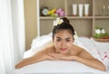 Young Asian woman enjoying in spa salon, Beauty therapist pouring salt scrub on woman back at health spa Royalty Free Stock Photo