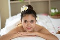 Young Asian woman enjoying in spa salon, Beauty therapist pouring salt scrub on woman back at health spa Royalty Free Stock Photo