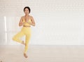 young asian woman exercising indoors, yoga class, standing in Vrksasana pose, tree pose, full length Royalty Free Stock Photo