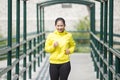 Young asian woman exercising outdoor in yellow neon jacket, jogging Royalty Free Stock Photo