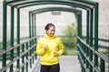 Young asian woman exercising outdoor in yellow neon jacket, jogging Royalty Free Stock Photo
