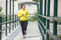 Young asian woman exercising outdoor in yellow neon jacket, jogging Royalty Free Stock Photo