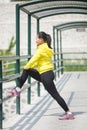 Young asian woman exercising outdoor in yellow neon jacket, stretching Royalty Free Stock Photo