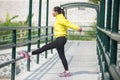 Young asian woman exercising outdoor in yellow neon jacket, stretching Royalty Free Stock Photo