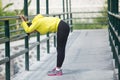 Young asian woman exercising outdoor in yellow neon jacket, stretching Royalty Free Stock Photo