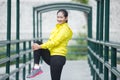 Young asian woman exercising outdoor in yellow neon jacket, stretching Royalty Free Stock Photo