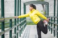 Young asian woman exercising outdoor in yellow neon jacket, stretching Royalty Free Stock Photo