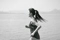 Young asian woman runner running outdoors by the sea Royalty Free Stock Photo