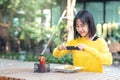 Young asian woman food blogger , vlogger or micro influencer taking photos for food blog using smartphone social network, sharing