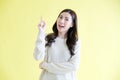 Young asian woman get idea while standing over isolated yellow background Royalty Free Stock Photo