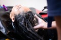 Young asian woman getting a hair wash by hairdresser at hair salon. Royalty Free Stock Photo