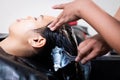 Young asian woman getting a hair wash by hairdresser at hair salon. Hairdresser washing hair of a young woman. Royalty Free Stock Photo