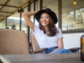 A young Asian woman is in a good mood sitting inside a cafe Royalty Free Stock Photo