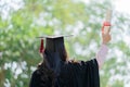 Young Asian woman hand holding diploma with a red ribbon of graduate student