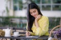 Young asian woman hand is writing on notepad with a pen in the garden Royalty Free Stock Photo