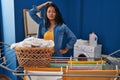 Young asian woman hanging clothes at clothesline confuse and wonder about question Royalty Free Stock Photo