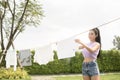 Young asian woman hanging laundry on washing line for drying against blue sky outdoor Royalty Free Stock Photo