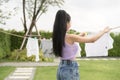 Young asian woman hanging laundry on washing line for drying against blue sky outdoor Royalty Free Stock Photo