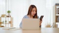 Young asian woman happy working on computer laptop and hand typing chat message Royalty Free Stock Photo