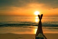 Young Asian woman with hat relaxing on the beach at sunset. Girl lying on sand beach. Upside woman bare feet at seaside. Holiday