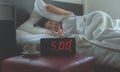 Young asian woman hates getting stressed waking up early 5 o`clock,Alarm clock Royalty Free Stock Photo